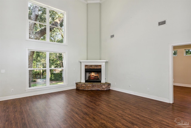 6814 Cedar Lake Dr, Pensacola, FL 32526 - unfurnished living room featuring a stone fireplace, dark wood-type flooring, a high ceiling, visible vents, and baseboards