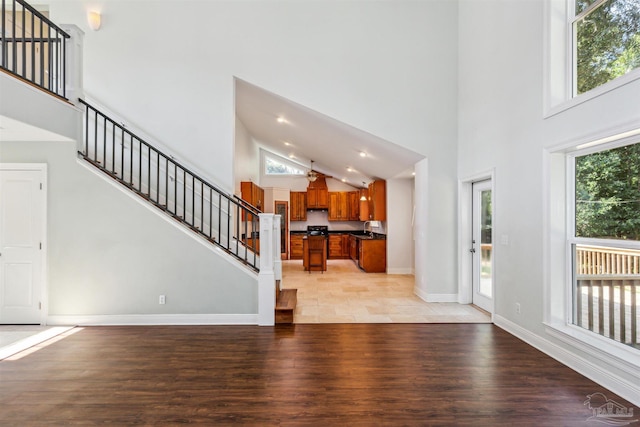 6814 Cedar Lake Dr, Pensacola, FL 32526 - living room featuring light wood-type flooring, stairs, baseboards, and a towering ceiling