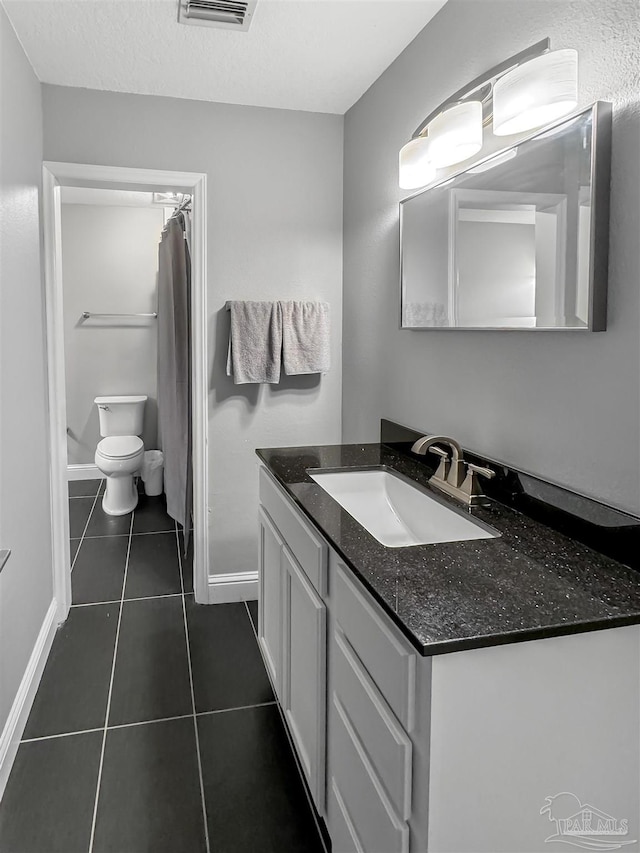 bathroom with tile patterned flooring, vanity, toilet, baseboards, and visible vents