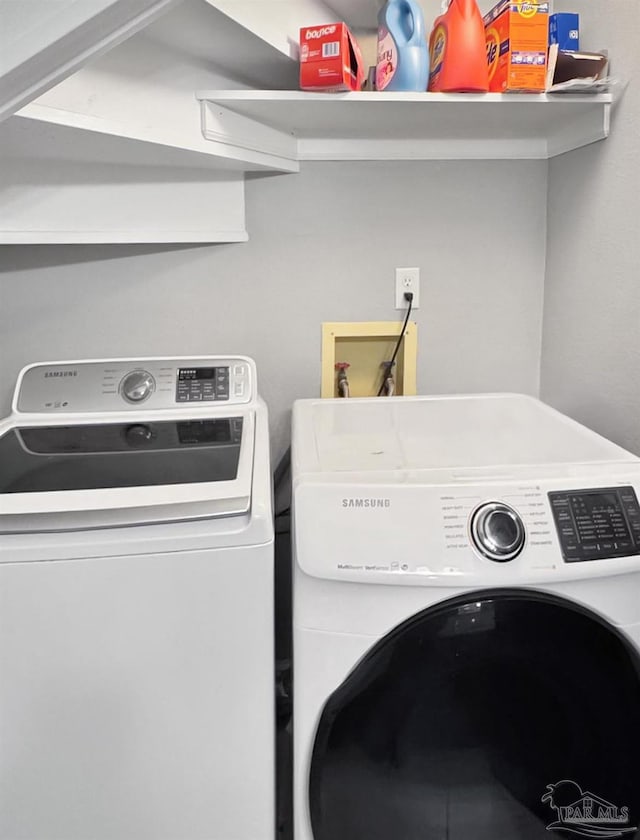 clothes washing area with independent washer and dryer and laundry area