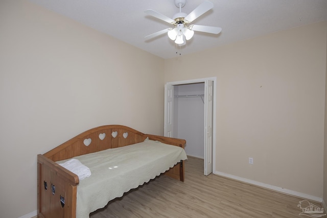 bedroom with ceiling fan, a closet, and light hardwood / wood-style floors