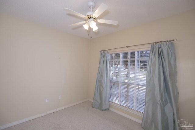 carpeted spare room featuring ceiling fan