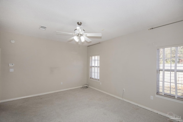 carpeted empty room with plenty of natural light and ceiling fan