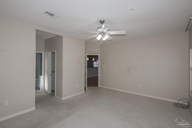 carpeted empty room featuring a textured ceiling and ceiling fan