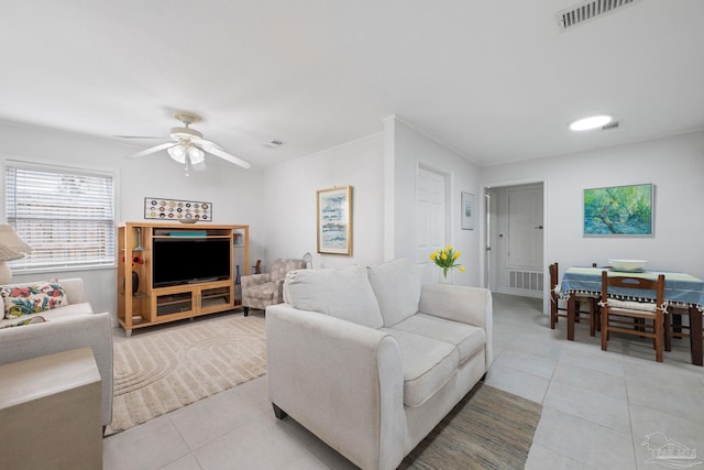 tiled living room featuring ornamental molding and ceiling fan