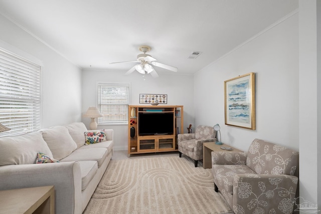 living room with crown molding, ceiling fan, and light carpet