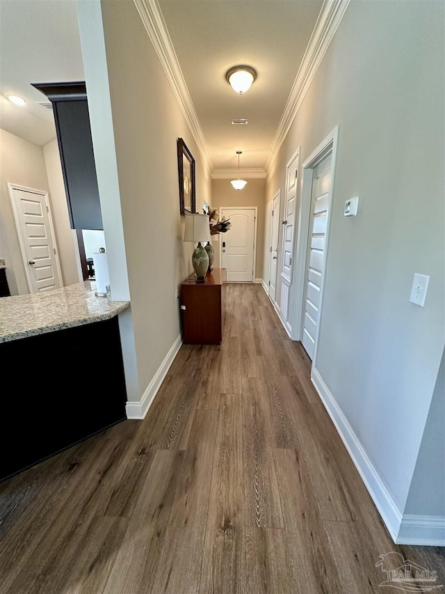 hall with dark hardwood / wood-style floors and ornamental molding