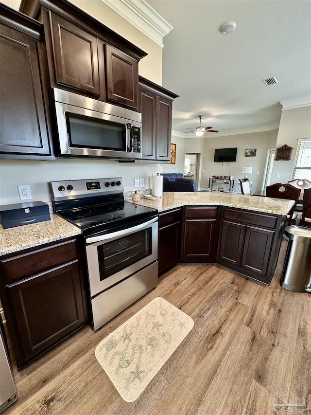 kitchen with light hardwood / wood-style flooring, appliances with stainless steel finishes, dark brown cabinets, and ornamental molding