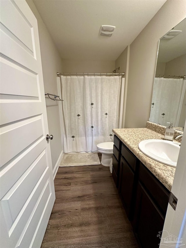 bathroom featuring toilet, vanity, and hardwood / wood-style floors