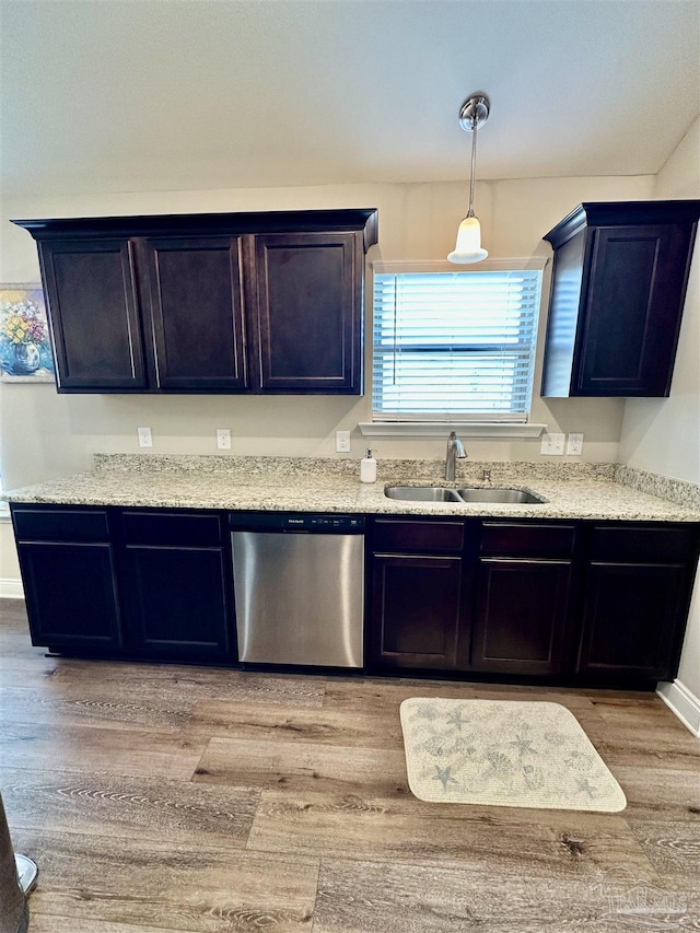 kitchen with light hardwood / wood-style flooring, sink, light stone counters, dishwasher, and pendant lighting