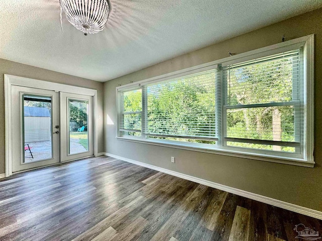 spare room featuring french doors, a textured ceiling, and hardwood / wood-style flooring