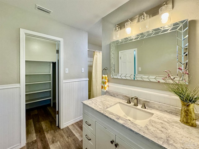 bathroom featuring hardwood / wood-style floors, vanity, and a textured ceiling