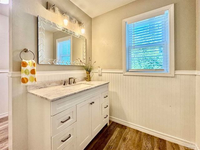 bathroom featuring hardwood / wood-style floors, vanity, and wooden walls