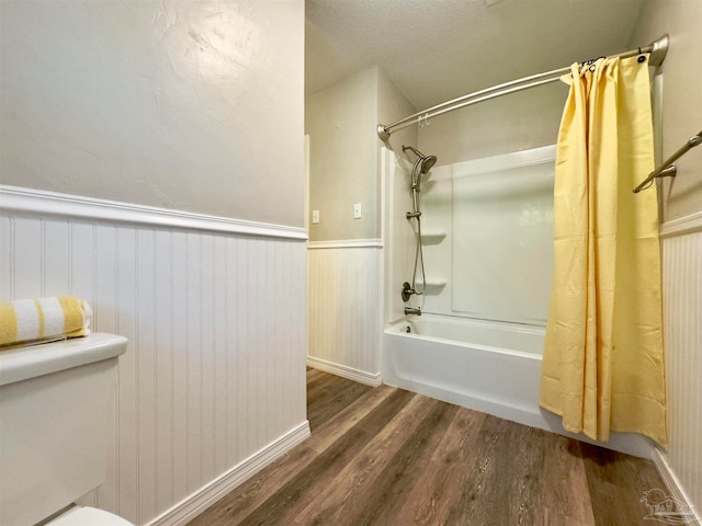 bathroom featuring hardwood / wood-style flooring, toilet, and shower / bathtub combination with curtain