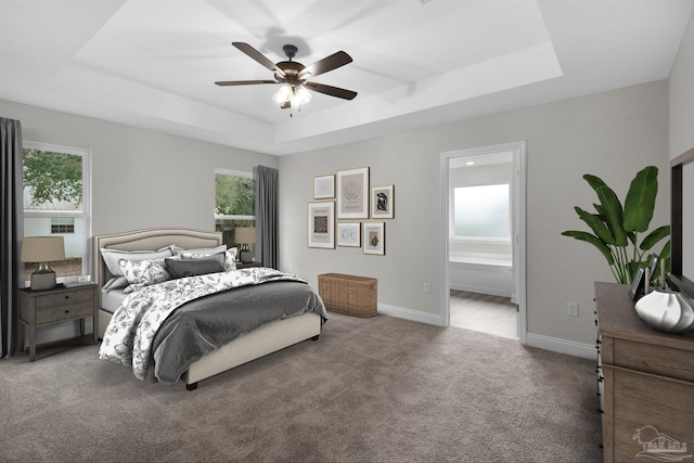 bedroom featuring carpet, ceiling fan, a raised ceiling, baseboards, and ensuite bathroom