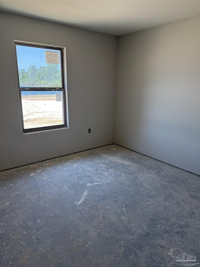 empty room with unfinished concrete flooring