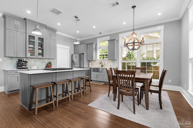 dining space with crown molding, a chandelier, recessed lighting, dark wood-type flooring, and baseboards