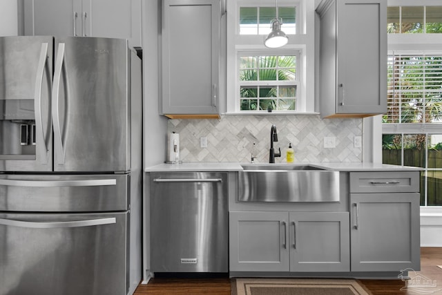 kitchen featuring appliances with stainless steel finishes, gray cabinetry, a sink, and light countertops