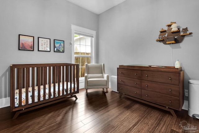 bedroom with wood finished floors and a nursery area