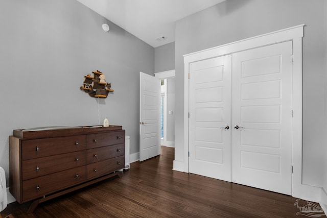 bedroom featuring dark wood-style floors, a closet, and baseboards