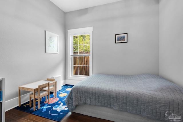 bedroom featuring wood finished floors and baseboards