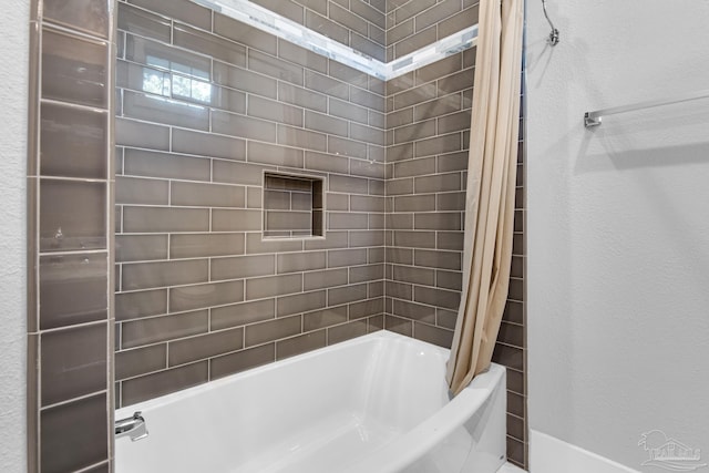 full bath with shower / tub combo and baseboards