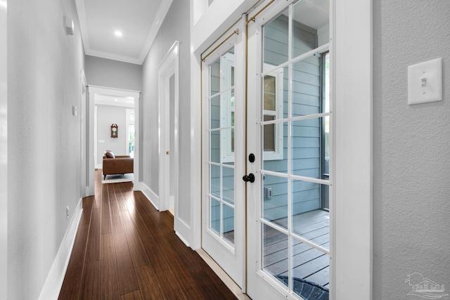 corridor with french doors, crown molding, wood finished floors, a textured wall, and baseboards