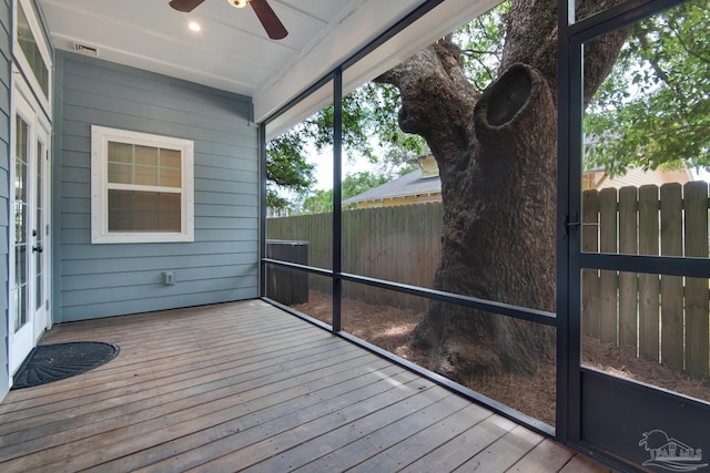 unfurnished sunroom with ceiling fan