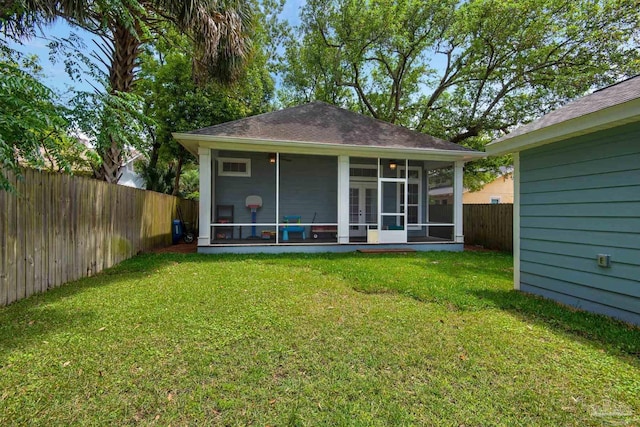 rear view of property featuring a sunroom and a shingled roof