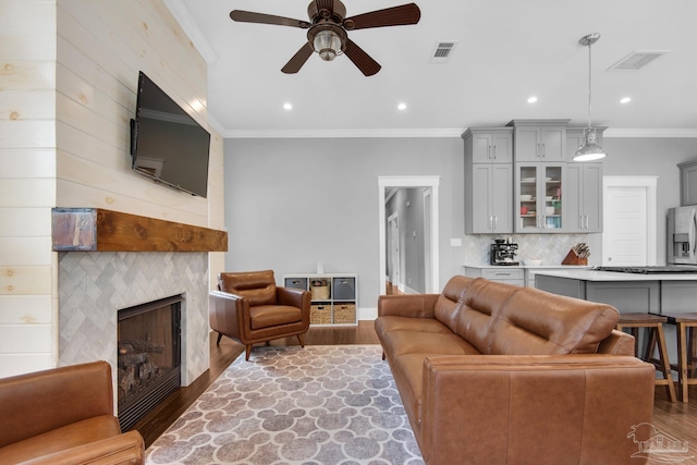 living room featuring wood finished floors, ceiling fan, recessed lighting, a large fireplace, and baseboards