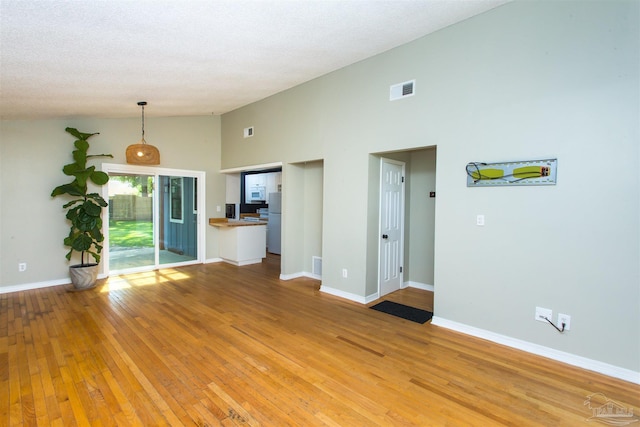 7402 Viewcrest Dr, Pensacola, FL 32504 - unfurnished living room featuring high vaulted ceiling, light wood-style flooring, and baseboards