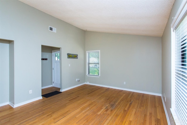 7402 Viewcrest Dr, Pensacola, FL 32504 - spare room featuring light wood-style floors, baseboards, high vaulted ceiling, and a textured ceiling