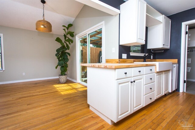 7402 Viewcrest Dr, Pensacola, FL 32504 - kitchen featuring light wood-style flooring, white cabinets, butcher block counters, pendant lighting, and baseboards