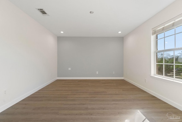 spare room with hardwood / wood-style flooring and plenty of natural light