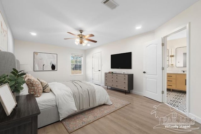 bedroom featuring ensuite bathroom, light hardwood / wood-style flooring, and ceiling fan