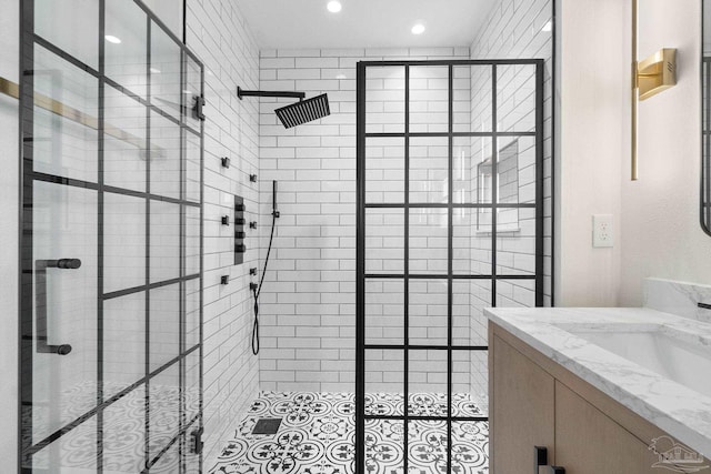 bathroom featuring tile patterned flooring, vanity, and tiled shower