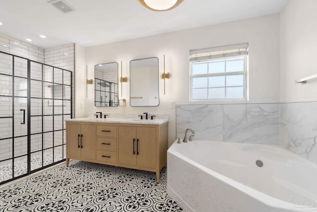 bathroom with tile patterned flooring, vanity, and shower with separate bathtub