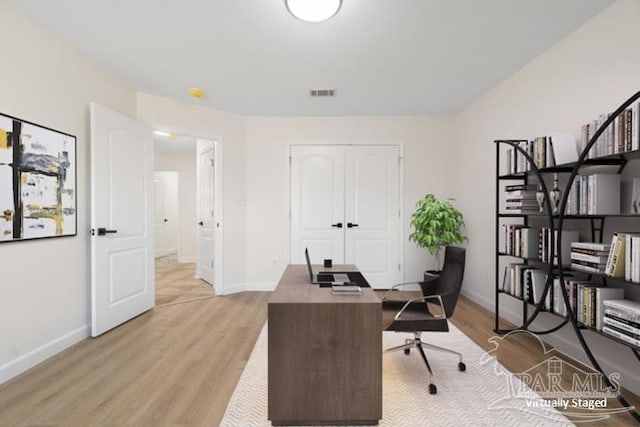 home office with light hardwood / wood-style flooring