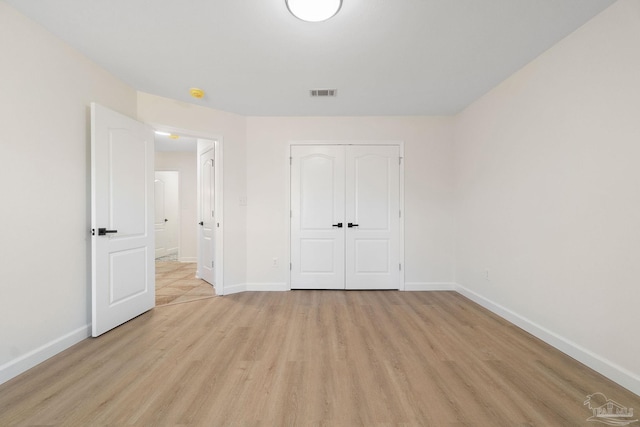 unfurnished bedroom with light hardwood / wood-style flooring and a closet