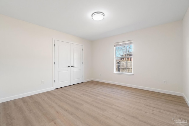 unfurnished bedroom featuring light hardwood / wood-style floors and a closet