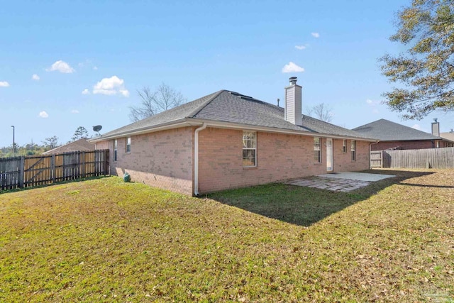 rear view of house featuring a lawn and a patio area