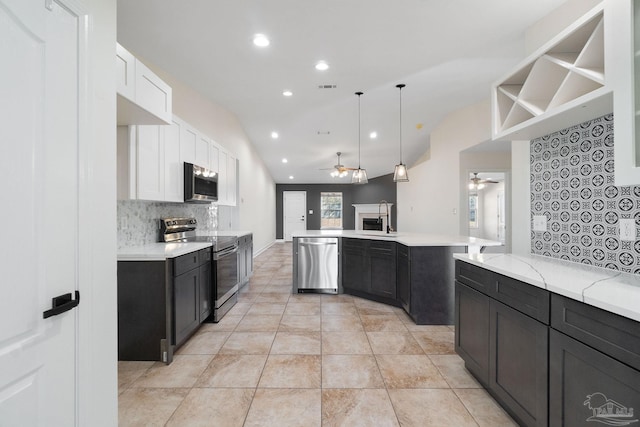 kitchen with white cabinetry, sink, hanging light fixtures, vaulted ceiling, and appliances with stainless steel finishes