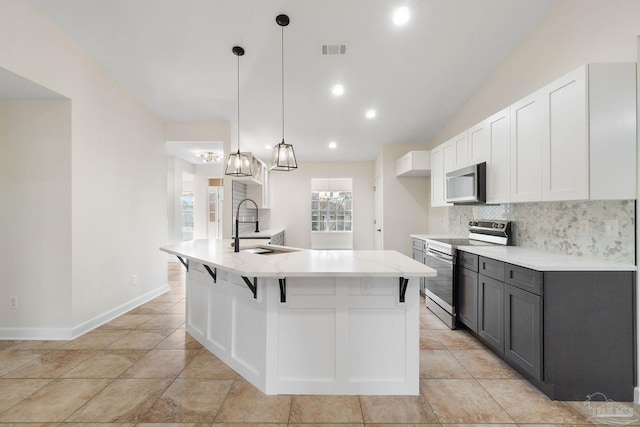 kitchen featuring stainless steel electric stove, pendant lighting, white cabinetry, and sink