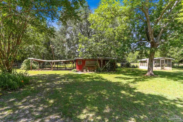 939 Avalon Blvd, Milton, FL 32583 - view of green lawn with an outdoor structure and a carport