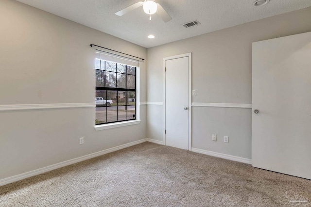 unfurnished room with visible vents, a ceiling fan, carpet flooring, a textured ceiling, and baseboards