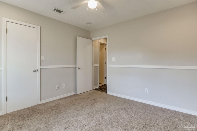 empty room with carpet, visible vents, ceiling fan, and baseboards