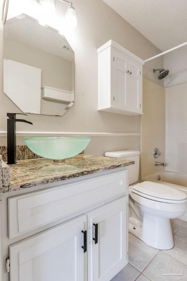 full bathroom with bathing tub / shower combination, toilet, tile patterned floors, a textured ceiling, and vanity