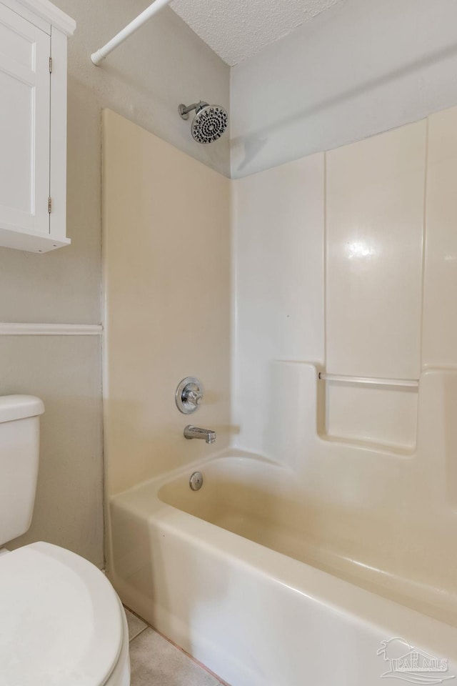 full bathroom with toilet, tile patterned flooring, tub / shower combination, and a textured ceiling