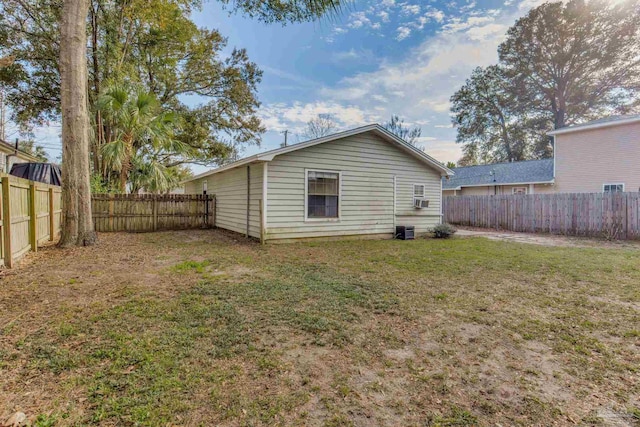 rear view of house featuring a fenced backyard and a lawn