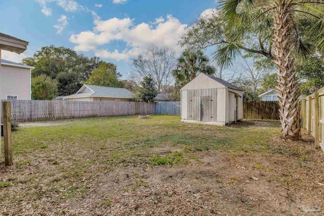 view of yard featuring a fenced backyard, a storage unit, and an outbuilding